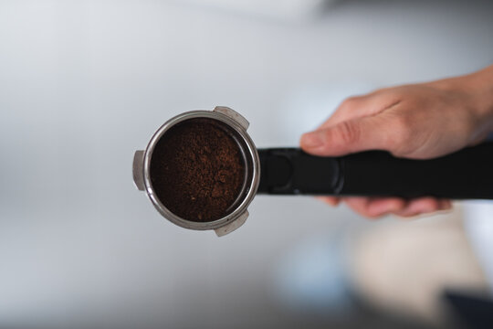 Preparing espresso with a portafilter and fresh coffee grounds