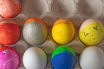 Easter eggs painted in bright colors in a cardboard box. Happy Easter concept.
