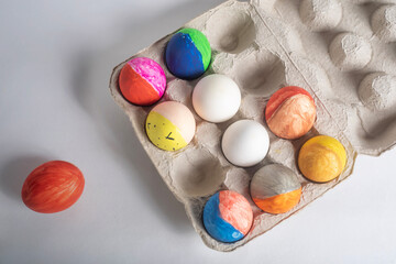 Colorful painted Easter eggs on a cardboard box on a white background