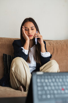 Bored young woman having a phone conversation at home