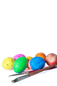 Colorful easter eggs and paint brushes isolated on white background