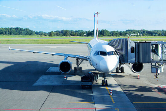 Airplane getting ready to accept passengers with ground crew working