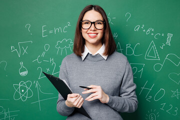 Young smiling fun smart teacher woman wear grey casual shirt glasses clipboard with paper documents...