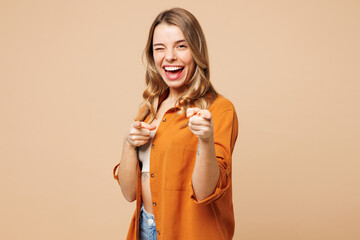 Young cheerful Caucasian woman she wear orange shirt casual clothes point index fingers camera on...