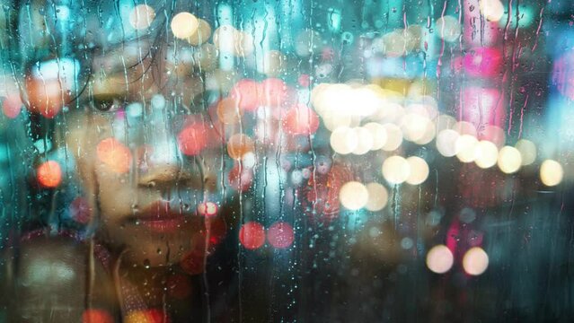 Sad girl in a rainy city.
Girl's face behind a rainy city window reflected car lights.
