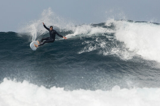 Dynamic Surfer Riding a Powerful Wave at Sea