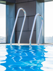 Serene Swimming Pool in Sweden With Stainless Steel Ladders Under Clear Skies