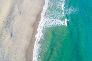 Aerial top view from drone of clean coastline under morning light.