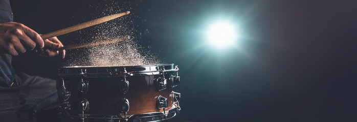 Drummer using drum sticks hitting snare drum with splashing water. - obrazy, fototapety, plakaty