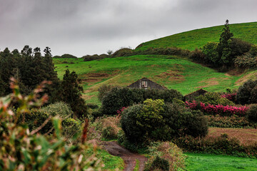 Road with old house on Azores islands, São Miguel, mountains and vegetation.