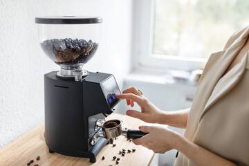 Woman barista make grinding coffee beans with machine - 767049643