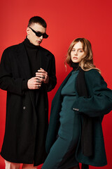 appealing long haired woman in elegant coat looking at camera near her boyfriend with sunglasses