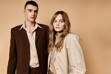 sophisticated young woman in stylish suit posing with her handsome boyfriend and looking at camera