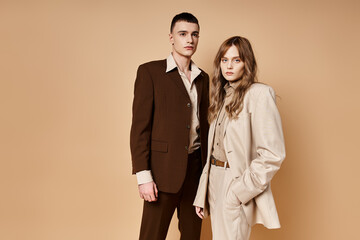 sophisticated young woman in stylish suit posing with her handsome boyfriend and looking at camera