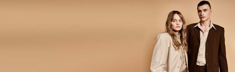 elegant woman in stylish suit posing with her handsome boyfriend and looking at camera, banner