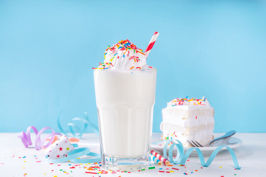 Birthday cake milkshake or smoothie drink.  Frozen homemade Birthday cake white vanilla ice cream floating cocktail with whipped cream, and colorful sugar sprinkles, funfetti