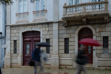 A rainy day in Lagos Portugal street people running to shelter. Deliberate motion blur used to create movement. tourist destination Algarve summer holiday place disappointing sunseekers in bad weather