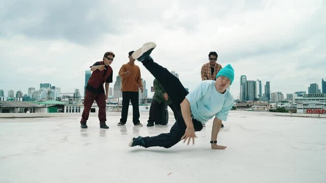 Professional break dance team practice B-boy dance while multicultural friends at rooftop. Young modern dancing group doing hip hop movement. Style,fashion,action. Outdoor sport 2024. hiphop.