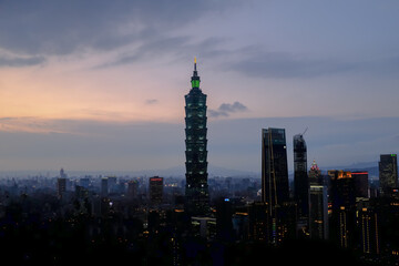 Fototapeta premium Aerial view of skyline of Taipei city with Taipei 101 Skyscraper at sunset from Xiangshan Elephant Mountain. Beautiful landscape and cityscape of Taipei downtown buildings and architecture in the city