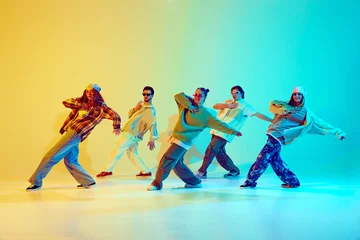 Photo sur Plexiglas École de danse Group of five dancers in casual clothes performing with synchronized poses against gradient green yellow background in neon light. Concept of modern dance style, hobby, active lifestyle, youth culture