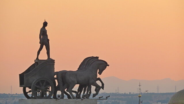 roman chariots statues madrid rooftops orange sky background top roof