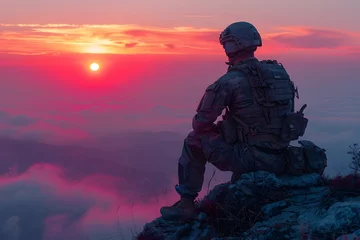 Selbstklebende Fototapeten Soldier Sitting on Top of Mountain at Sunset © D