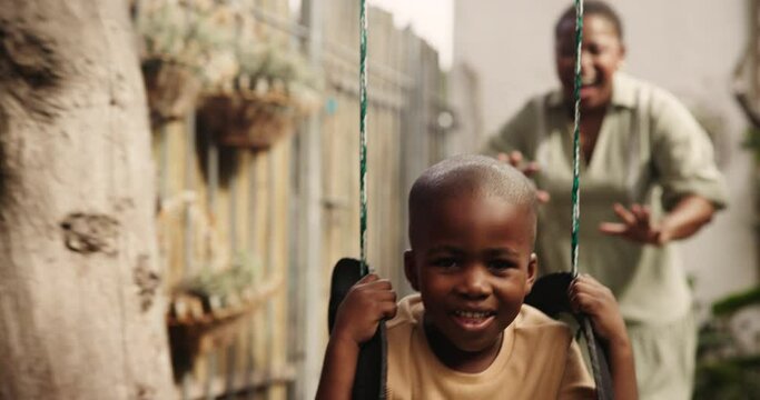 Love, swing or mother and son in a backyard for playing, fun or bonding in outdoor garden together. Black family, games and mom swinging kid in a park with care, support and freedom at a playground