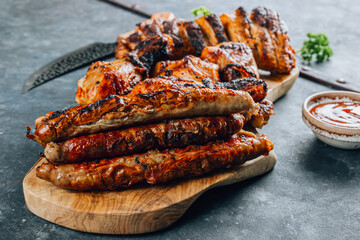 Various grill and bbq meat : chicken legs, pork steaks, sausage and sauce