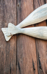 Carved wooden fishes tails on the old boards - 767074662