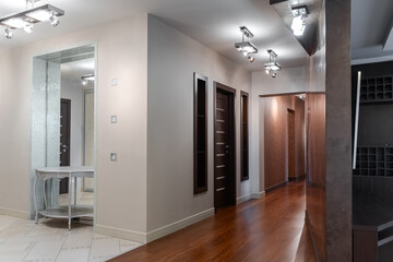 empty corridor with wooden doors to other rooms in modern house