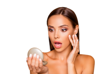 Brown-haired lady with her naked shoulders she looks at mirror stand half turn with upset face open mouth staring eyes isolated on pastel beige background tousc cheek