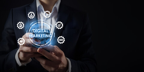 A businessman holds a smartphone displaying marketing icons symbolizing digital marketing technology, business innovation, online promotion, tech-savvy entrepreneur concept