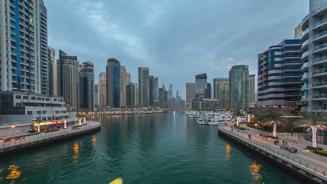 Evening Dubai marina city center with floating vessels day to night timelapse