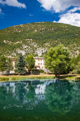 Fototapeta na wymiar The beautiful village of Villalago, in the province of L'Aquila in Abruzzo, central Italy. The small lake near the town centre, immersed in the nature of the green Abruzzo mountains.