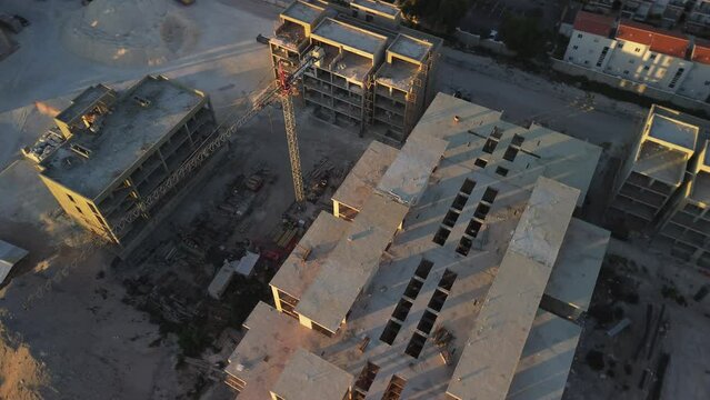 Drone view of large construction site on Sunset located along seashore 