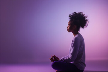 Peaceful determined curly young Afro American woman makes zen gesture, has yoga breathing practice, meditates indoor