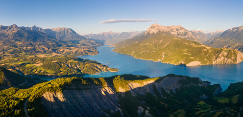 Serre-Poncon Lake and Durance Valley with Grand Morgon peak at sunset. Aerial view of Chanteloube...