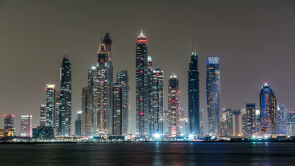 Dubai Marina skyline night timelapse as seen from island in Dubai, UAE.