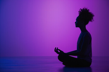 Peaceful determined curly young Afro American woman makes zen gesture, has yoga breathing practice, meditates indoor - obrazy, fototapety, plakaty