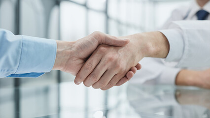 Business partnership meeting in office. Close up of handshake in the office.