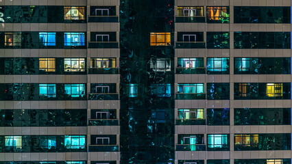 window of the multi-storey building of glass and steel lighting and people within timelapse