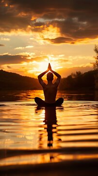 Man in yoga pose, zen meditation at sunset 