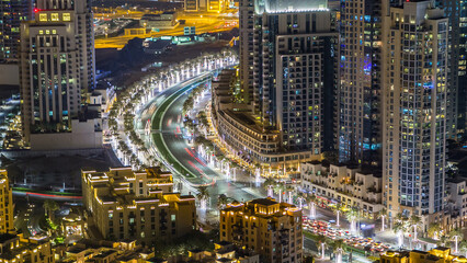 Top view of road in Dubai downtown timelapse with night traffic and illuminated skyscrapers.