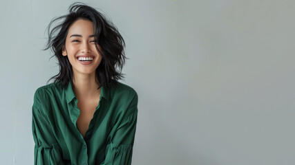 Malay woman wearing green shirt smiling laugh out loud isolated on grey - obrazy, fototapety, plakaty