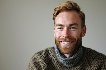 Portrait of a handsome man in a sweater smiling at the camera - obrazy, fototapety, plakaty