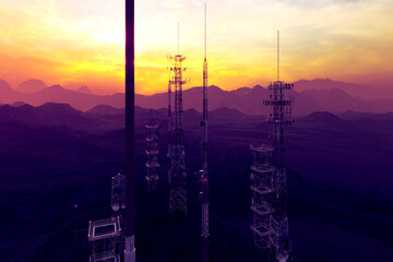 Vibrant Sunset Silhouetting Communication Towers Amidst Mountains