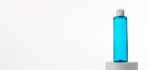 Makeup remover in plastic blue bottle isolated on white background. Natural organic beauty liquid product. Micellar water for cleansing and moisturizing facial skin..