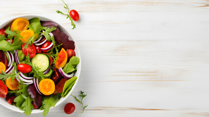 Tasty salad in bowl on white wooden background with copy space. Healthy fresh vegetable, fruit and grain. Topview