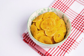 Green banana chips on cloth and white background