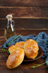 Cabbage pies on wooden background. Baked homemade pirozhki with cabbage